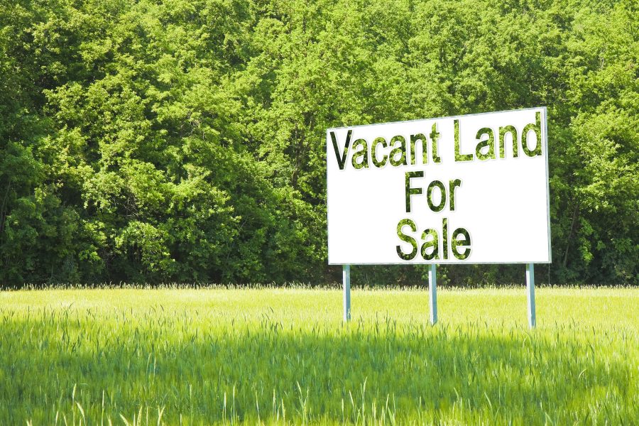 Advertising billboard immersed in a rural scene with Vacant Land for Sale written on it